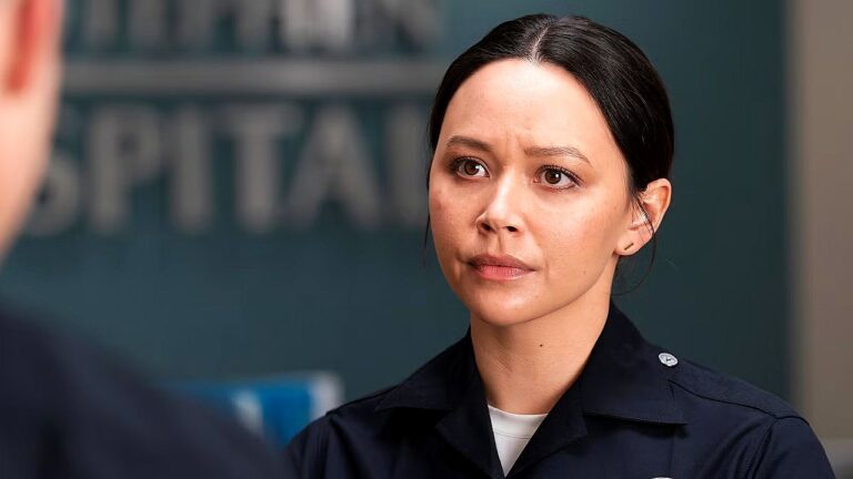 Policial feminina com expressão séria conversa com alguém em cena de série policial em delegacia