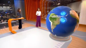 Apresentadoras interagem diante de telão com globo 3D e mapa da América do Sul exibindo ventos alísios no estúdio do Bom Dia Brasil