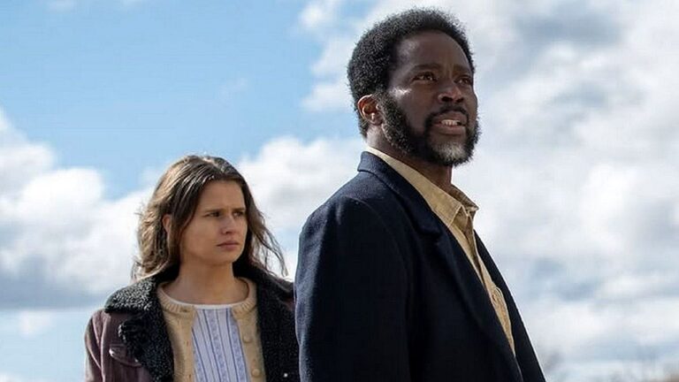 Homem e mulher observam horizonte sob céu nublado em cena ao ar livre de série ou filme