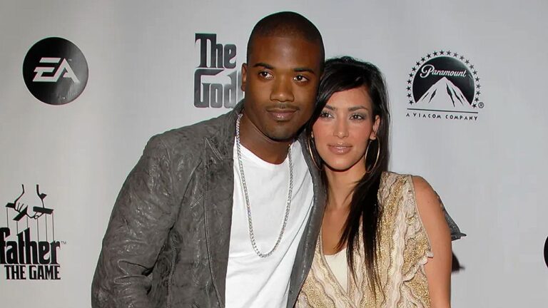 Casal posa junto em evento de The Godfather com logos da Paramount e EA ao fundo