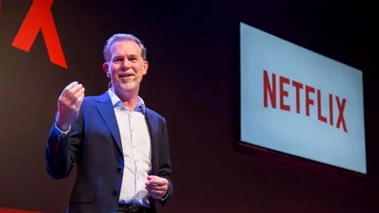 Executivo apresenta a Netflix em palco durante evento corporativo com logotipo exibido em telão ao fundo