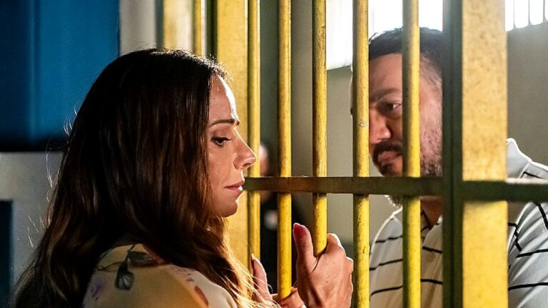Mulher conversa com homem separado por grades de cela em cena de prisão em série ou novela