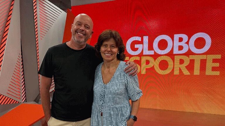 Apresentadores posam no estúdio do Globo Esporte diante do telão com logotipo do programa