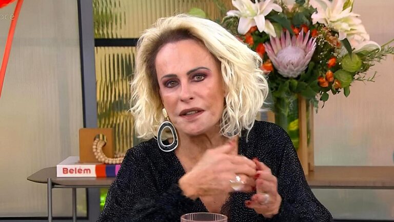 Ana Maria Braga conversa em programa matinal diante de arranjo de flores e decoração de estúdio ao fundo