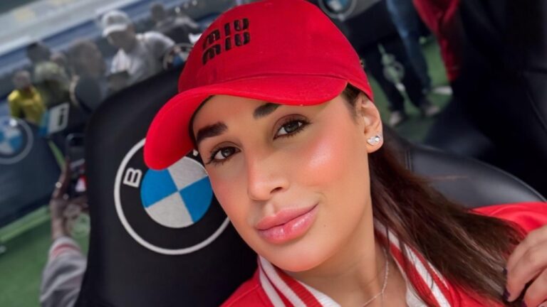 Bruna Pinheiro posa de boné vermelho em área VIP de estádio