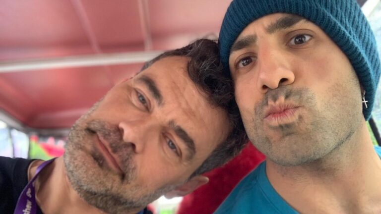 Carmo Dalla Vecchia e Kaysar Dadour posam juntos em selfie dentro de veículo com teto vermelho fazendo caretas para a câmera