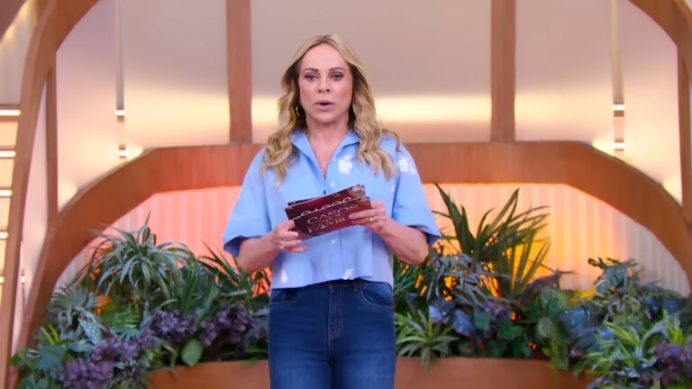 Christina Rocha apresenta o Casos de Família em cenário com plantas e cartões do programa nas mãos.