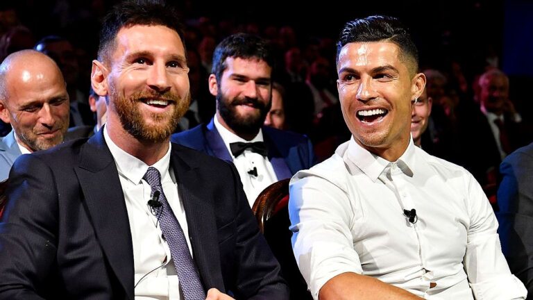 Lionel Messi e Cristiano Ronaldo sorriem durante premiação em evento do futebol mundial