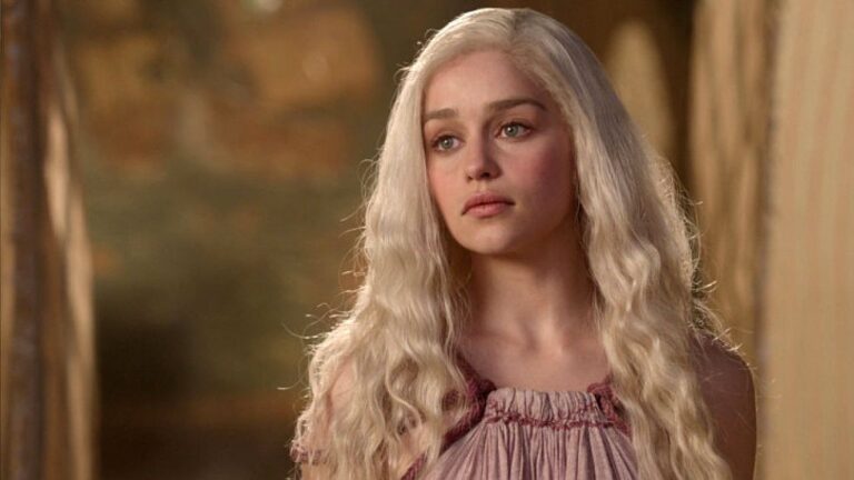 Mulher de cabelos brancos e vestido rosa com expressão séria em cena de House of the Dragon