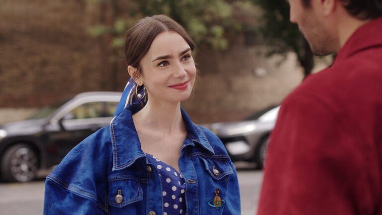 Mulher com jaqueta jeans azul conversa com homem em rua em cena de Emily em Paris