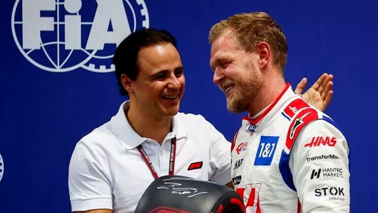 Homens da Fórmula 1 conversam nos bastidores diante de painel da FIA após corrida da Haas