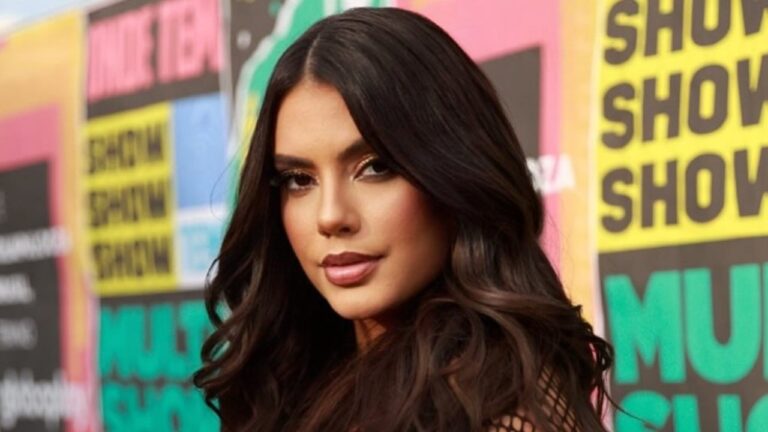 Fernanda Bande com cabelos longos posa diante de painel colorido em evento do Multishow