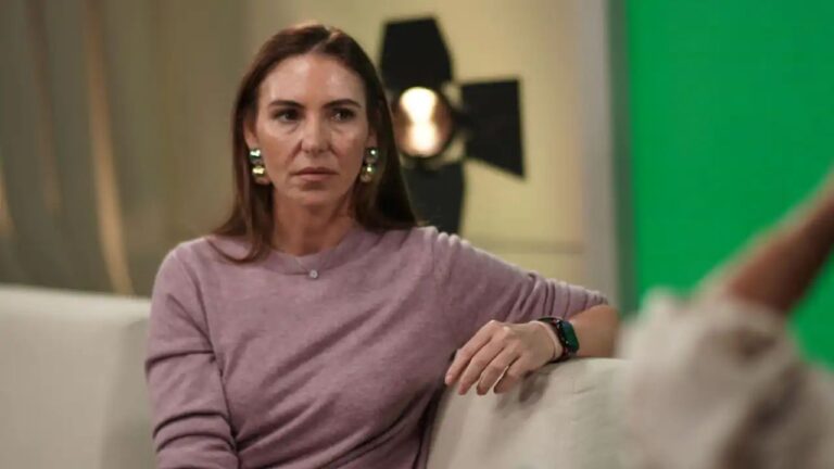 Mulher de blusa lilás conversa em estúdio durante gravação de programa de televisão