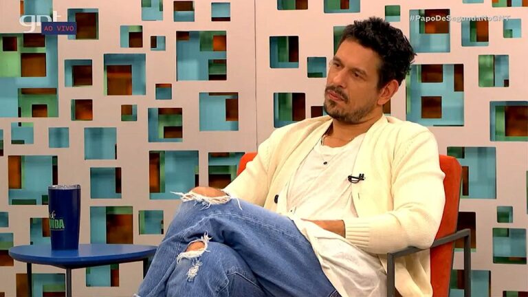 Ator participa do Papo de Segunda no GNT sentado em poltrona durante programa ao vivo