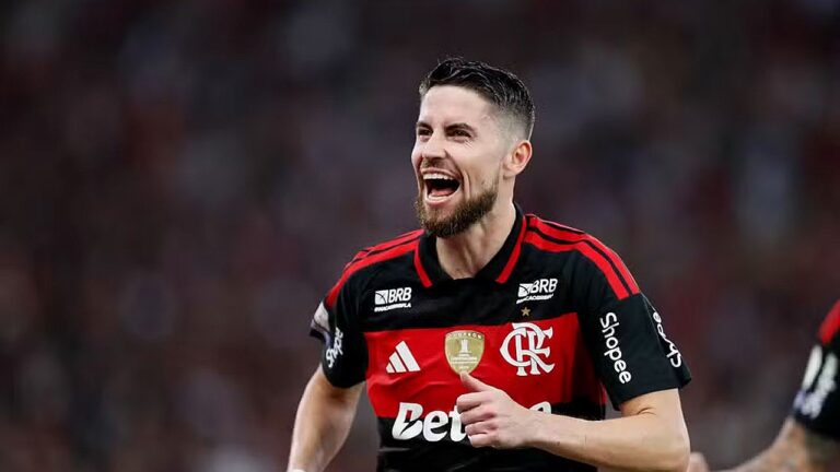 Jogador do Flamengo comemora em campo usando uniforme rubro-negro durante partida de futebol