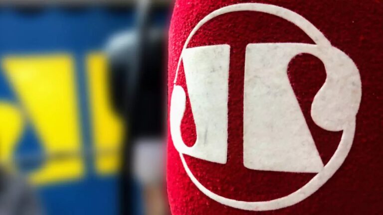 Microfone da Jovem Pan com logotipo da emissora em destaque e fundo desfocado
