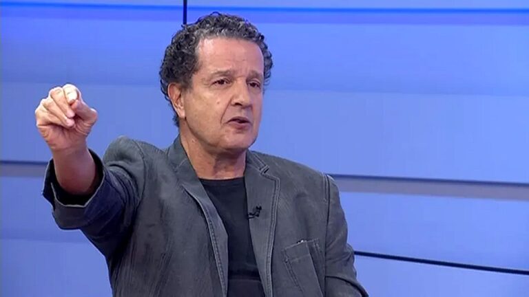 Juca Kfouri gesticula durante participação em programa esportivo de televisão com cenário azul ao fundo