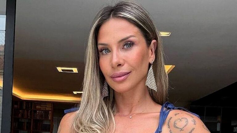 Influenciadora fitness posa com vestido azul e brincos longos em foto publicada nas redes sociais