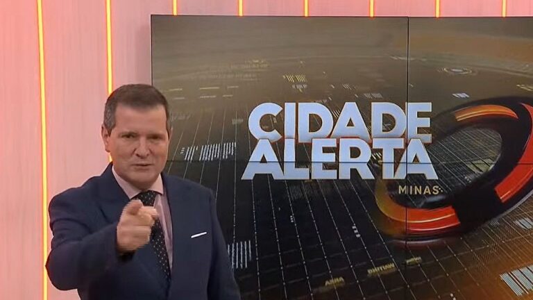 Apresentador aponta para câmera no estúdio do Cidade Alerta Minas durante edição do telejornal