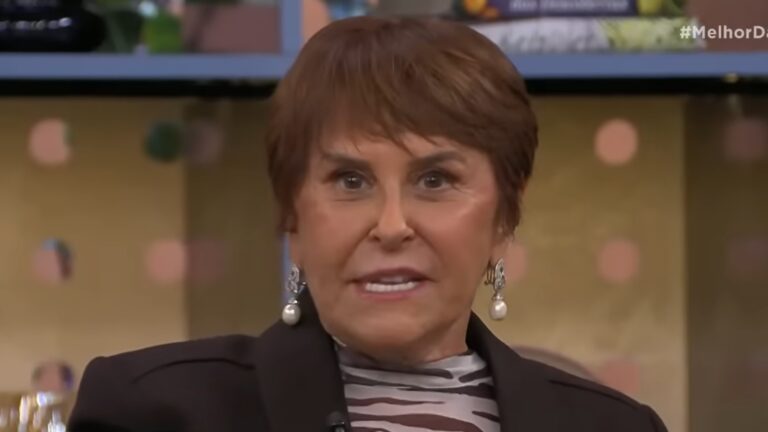Márcia Sensitiva, uma mulher com cabelo curto e brincos de pérola, fala durante participação no Melhor da Tarde, em estúdio com cenário iluminado.