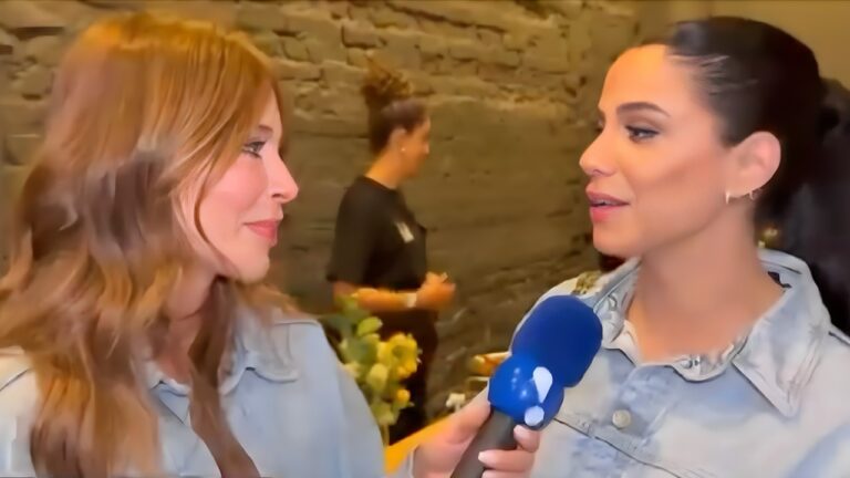 Naty Curvelo entrevista Key Alves com microfone da RedeTV! durante evento em ambiente interno com parede de pedra