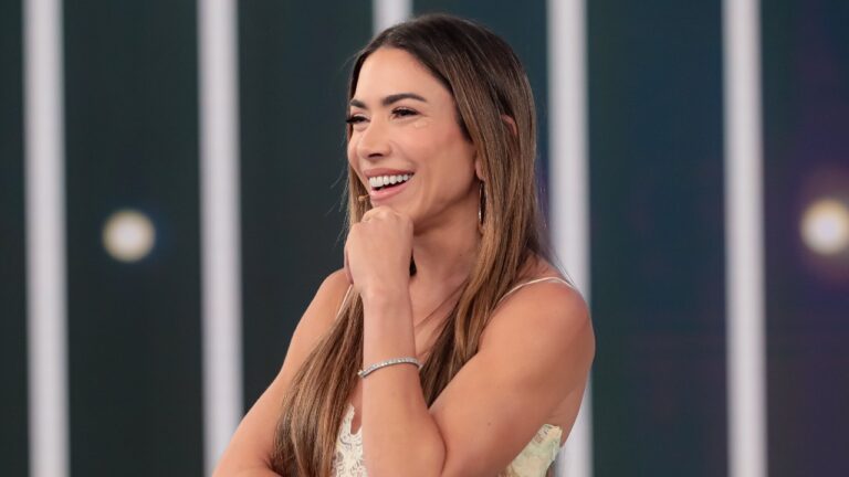 Patricia Abravanel sorrindo durante apresentação do Programa Silvio Santos em cenário iluminado do SBT