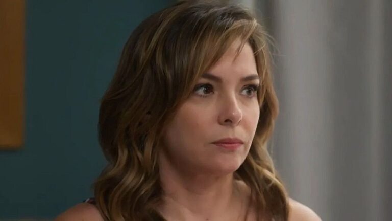 Mulher de cabelo castanho observa alguém com expressão séria em cena de novela brasileira