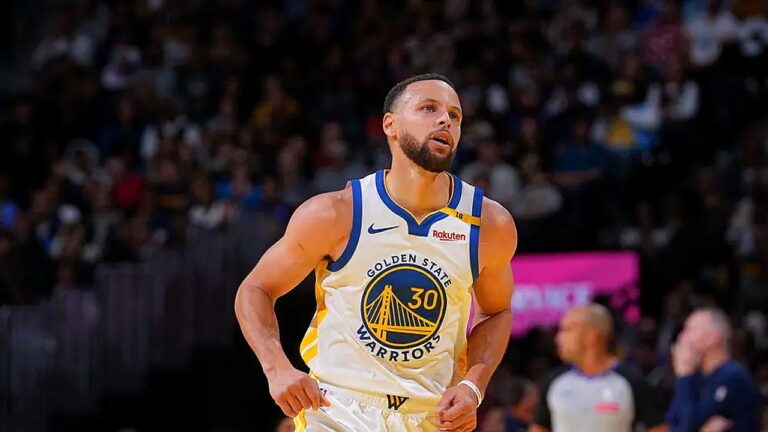 Jogador do Golden State Warriors corre em quadra durante partida da NBA com torcida ao fundo