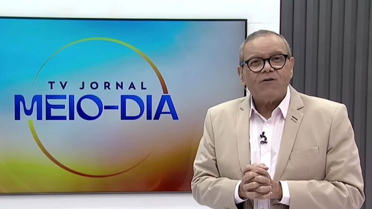 Homem de óculos apresenta o TV Jornal Meio-Dia em estúdio de telejornal local