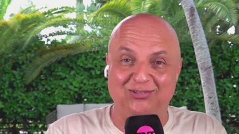 André Henning fala ao microfone durante entrada ao vivo com fones de ouvido e jardim ao fundo