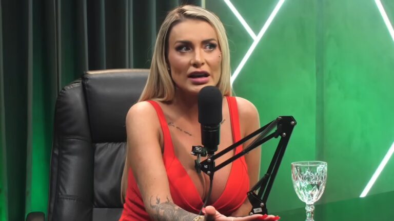 Andressa Urach de vestido vermelho fala ao microfone durante gravação de podcast em estúdio com iluminação verde ao fundo