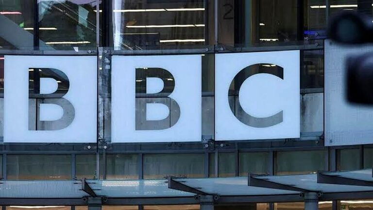 Logotipo da BBC exibido na fachada de prédio de vidro da emissora no Reino Unido