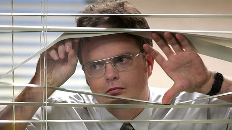 Ator observa pela persiana em cena da série The Office