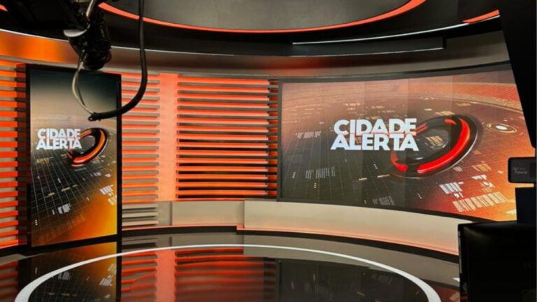 Estúdio do Cidade Alerta com telões exibindo o logotipo do programa e iluminação vermelha em cenário de televisão
