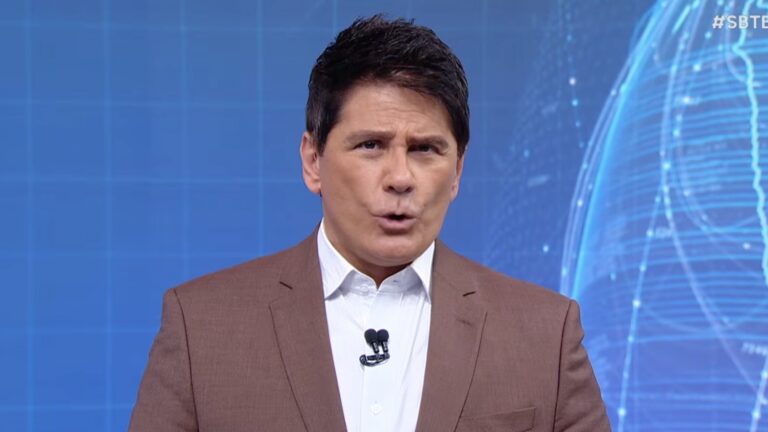 Cesar Filho, de blazer marrom e camisa branca, fala diante de painel azul com globo digital no SBT Brasil