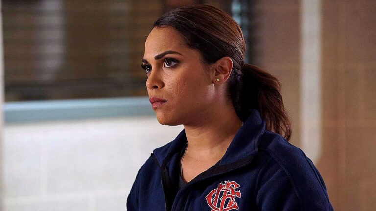 Bombeira com uniforme do Corpo de Bombeiros observa atentamente em cena da série Chicago Fire