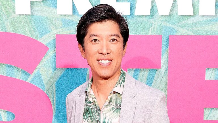 Dan Lin sorri diante de painel promocional durante estreia de filme em evento de Hollywood