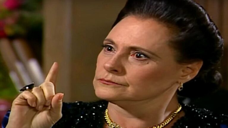 Elizabeth Savala com expressão severa e dedo em riste durante discussão em cena de novela brasileira