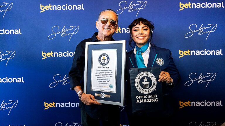 Galvão Bueno segura certificado do Guinness World Records ao lado de representante da entidade durante evento promocional do narrador