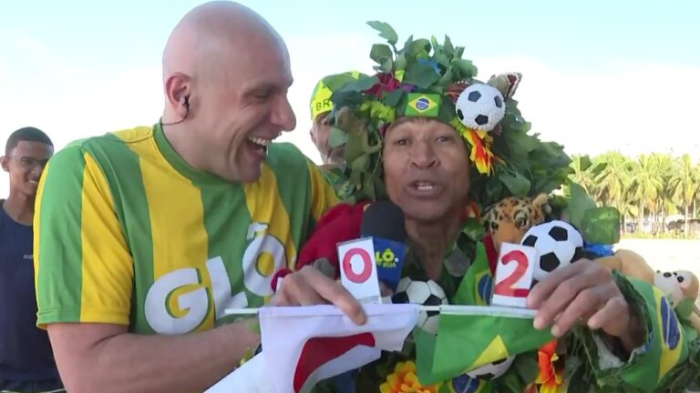 Ivo Madoglio sorri ao lado de torcedor fantasiado com adereços da seleção brasileira durante participação no Encontro