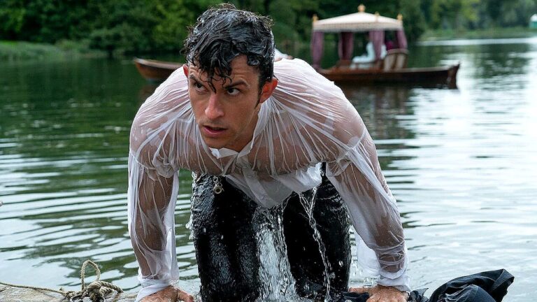 Jonathan Bailey emerge encharcado de lago com camisa branca molhada em cena de série