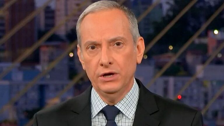 Jose Roberto Burnier em um terno com um estúdio escuro no fundo