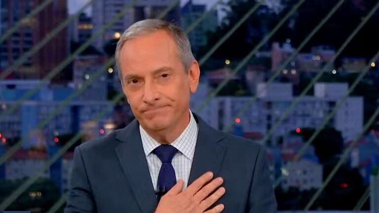José Roberto Burnier durante apresentação de telejornal da TV Globo com cenário urbano ao fundo