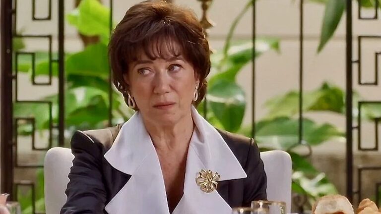 Lilia Cabral com expressão preocupada durante jantar em cena de novela ambientada em sala de estar