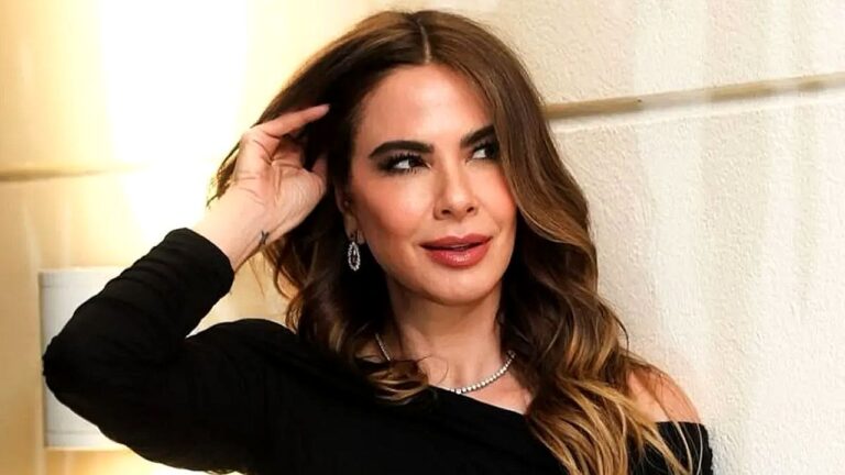 Luciana Gimenez com vestido preto e cabelo ondulado durante evento posa olhando para o lado