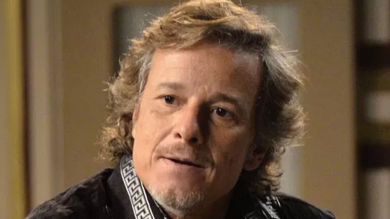 Marcello Novaes em cena de novela durante conversa com expressão séria dentro de casa