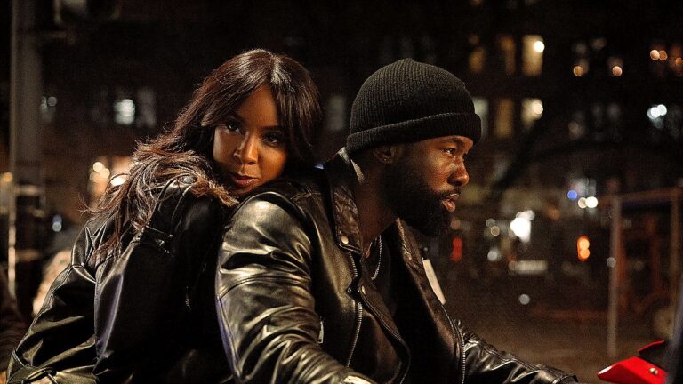 Kelly Rowland e Trevante Rhodes em motocicleta durante cena noturna do filme Mea Culpa