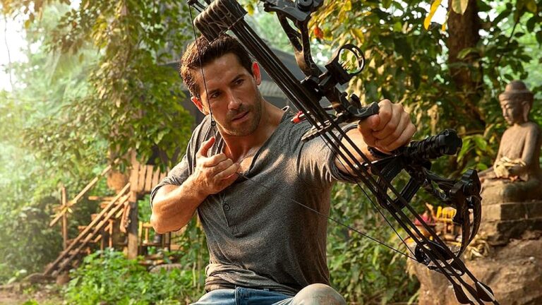 Frank Grillo mira com arco e flecha em área de floresta em cena do filme de ação O Alvo 2