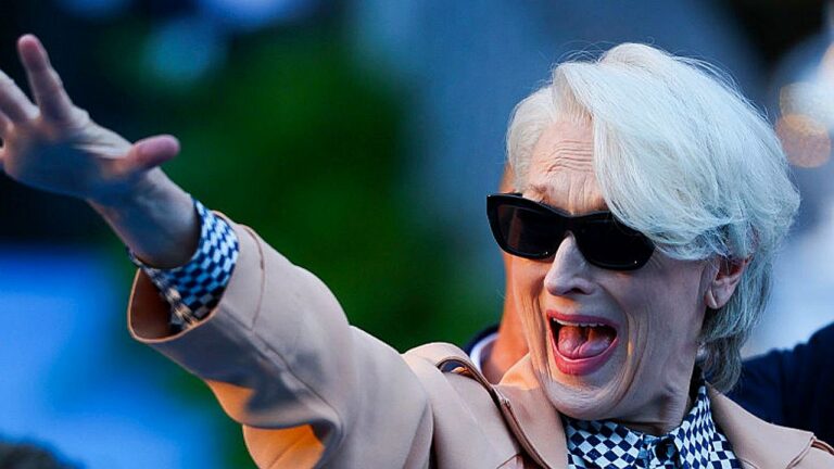 Miranda Priestly com óculos escuros faz gesto para a multidão em cena do filme O Diabo Veste Prada