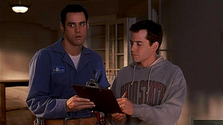 Jim Carrey e Matthew Broderick observam prancheta em cena do filme O Pentelho